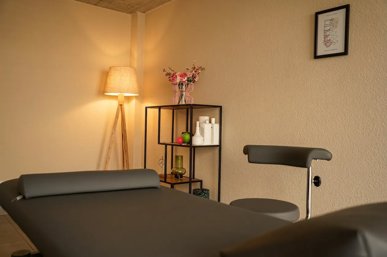 Behandlungsraum mit Liege, Stehlampe und Regal